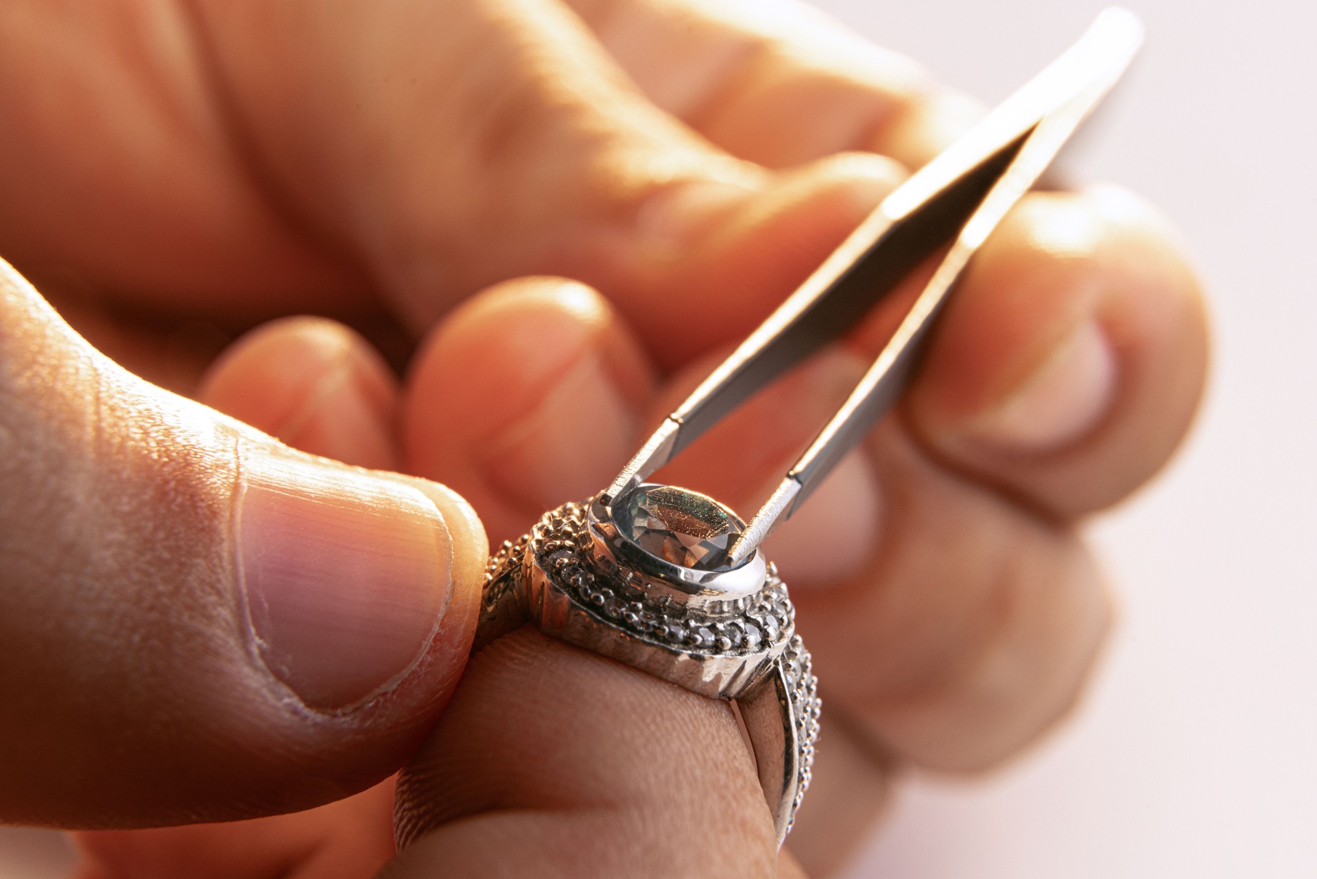 Working process. Closeup hands of jeweler at work in jewelry. Desktop for craft jewelry making with professional tools.